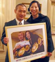 V2祝勝会で本紙贈呈のパネルを手に喜ぶ名城と智子夫人