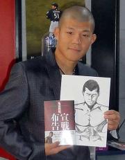 著書と弟大毅が描いたイラストを手にする亀田興毅