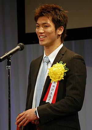 年間表彰式でスピーチする、アマMVPの村田(共同)