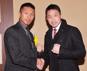 年間表彰式に臨み握手する粟生(右)と内山(撮影・下田雄一)