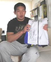 読者プレゼントのジャージーを手にする石井（撮影・浜本卓也）