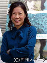 主演のオダギリジョーが写るポスターの前で笑顔を見せる西川美和監督