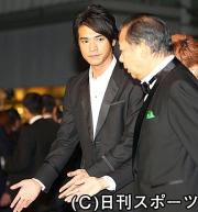 二階俊博経産相（右）をエスコートする金城武