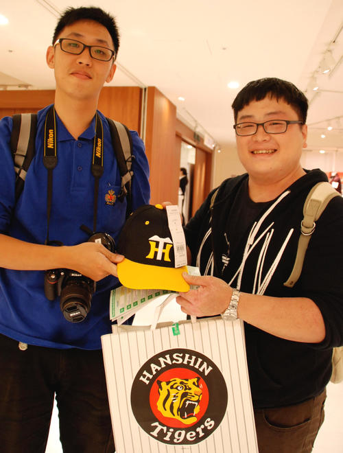友人と阪神百貨店を訪れ、阪神タイガースの帽子を購入したチャン・ウェイさん（右）（撮影・松浦隆司）