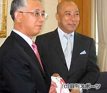 石川県東京事務所の代表に義援金を手渡す市川団十郎（右）