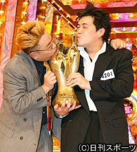 Ｍ－１優勝のサンドウィッチマンの伊達（左）と富沢はトロフィーにキスをする