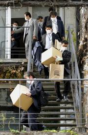 篠山紀信さんの事務所から押収物を運び出す警視庁の捜査員ら(共同)