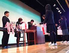 舞台上で坪井次長（右）から表彰状を授与される生徒