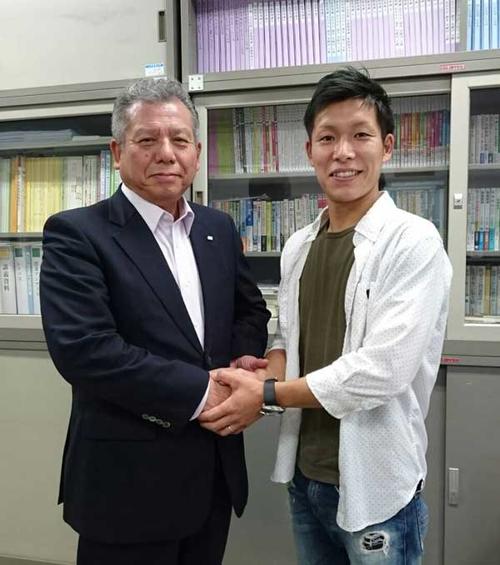 恩師の田中靖人先生（左）とがっちり握手する田中京介選手