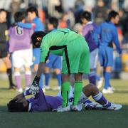 ピッチに倒れ込む藤枝東FW新井(左)は大津GK江藤から声を掛けられる