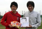 高橋陽一氏（右）から似顔絵をプレゼントされる鹿島ＤＦ内田
