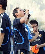 のどを潤す岡田監督(撮影・為田聡史)