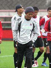 練習後、選手とともに険しい表情で歩く石崎監督(中央)