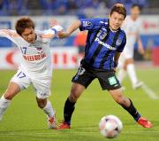 後半、競り合うG大阪MF安田理(右)と新潟DF内田(撮影・河南真一)