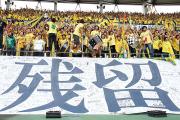 残留とかかれた巨大フラッグを掲げ応援する千葉サポーター