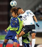 横浜FCのFWカズは、DFをかわしヘディングを放つがゴールならず