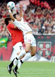 後半、DF永田(左)と激しく接触し、倒れる大久保(撮影・栗山尚久)