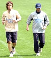 ゆっくりとランニングするMF本田(左)