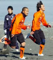 MF小野(左)と競り合いながら砂浜ダッシュをするFW永井