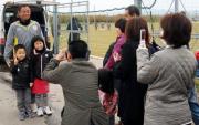 練習場に駆けつけたサポーターと、記念撮影する小林監督（左端）