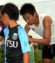 子どもの背中にサインする川崎Ｆ・ＦＷ我那覇