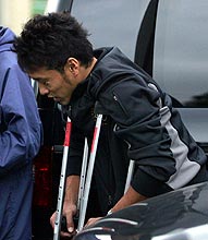 山田は、松葉づえ姿で報道陣の質問に答える