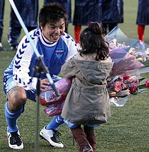 城は引退試合が終わり長女の夢叶ちゃんから花束をもらう(撮影・鹿野芳博)