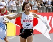女子マラソンで２位となり日の丸を背に喜ぶ尾崎好美（共同）