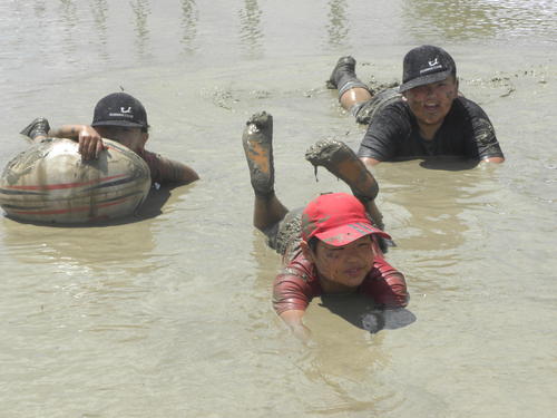 たんぼに寝そべり、泥だらけになる子どもたち（撮影・松本航）（２０１８年６月１７日）