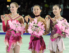 女子で優勝し、金メダルを手に笑顔の浅田真央。左は２位のカロリナ・コストナー、右は３位の金妍児（共同）