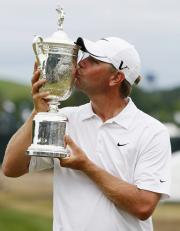 全米OPを制し、優勝カップにキスをするルーカス・グローバー(共同)