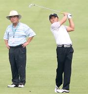 父護さん（左）が見守る中、ショットを放つ丸山茂樹（撮影・たえ見朱実）
