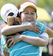 開幕戦から2週連続優勝を果たし、同組の上田と抱き合う宮里(共同)