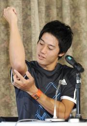 記者会見で疲労骨折した右ひじを見せる錦織圭（共同）
