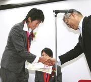 古川社長(右)と握手する北京五輪ソフトボール日本代表の上野(共同)
