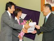 同大の八田学長(右)に北京五輪の報告をする朝原(左)と早狩(共同)