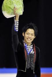 故障明けの復帰戦で優勝し、表彰式で花束を掲げて喜ぶ高橋大輔（共同）