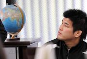 記者会見する井上康生。地球儀は北京が位置する東経116度を指していた