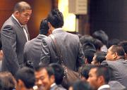 解団式の前、柔道金メダルの石井慧(左)は斉藤監督(右端)と話す