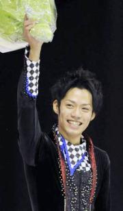 表彰式で花束を掲げて喜ぶ高橋大輔（共同）
