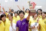 笑顔でスタンドの部員に優勝カップを掲げる植松