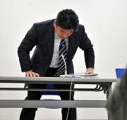 明大・吉田監督は、報道陣に頭を下げ会見場を後にする（撮影・下田雄一）