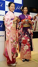 写真展会場でカメラを手にポーズをとる浅田真央（左）と浅田舞