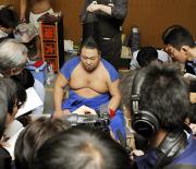 大関からの転落が決まり、支度部屋で記者に囲まれる千代大海(共同)