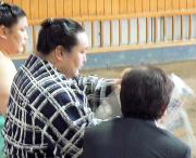 本田医師(右)と雑談をしながら新聞を読む朝青龍(中央)。左は朝赤龍