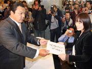 初の親方サイン会でファンの女性に色紙を手渡す九重親方