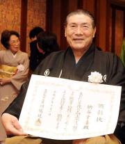 相撲界から初の文化功労者となった元大鵬の納谷氏は、顕彰状を手に笑顔
