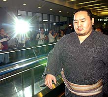 無表情のままモンゴルへ出発する朝青龍(撮影・水谷安孝)