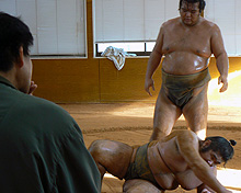 ぶつかりげいこで転ぶ貴輝鳳（右下）を指導する貴乃花親方（左）