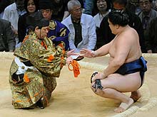 木村玉光から懸賞を受け取る朝赤龍（撮影・岡本肇）
